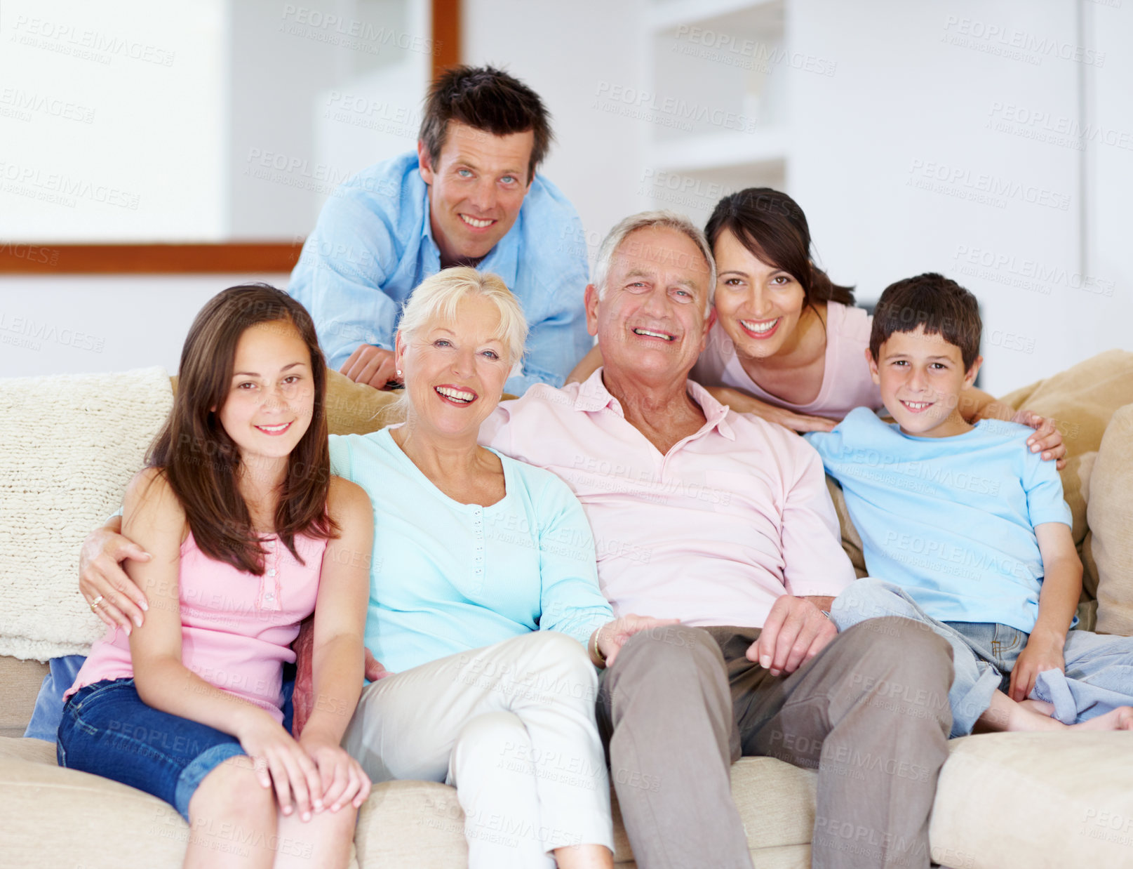 Buy stock photo Three generations of family sitting together affectionately on the lounge couch