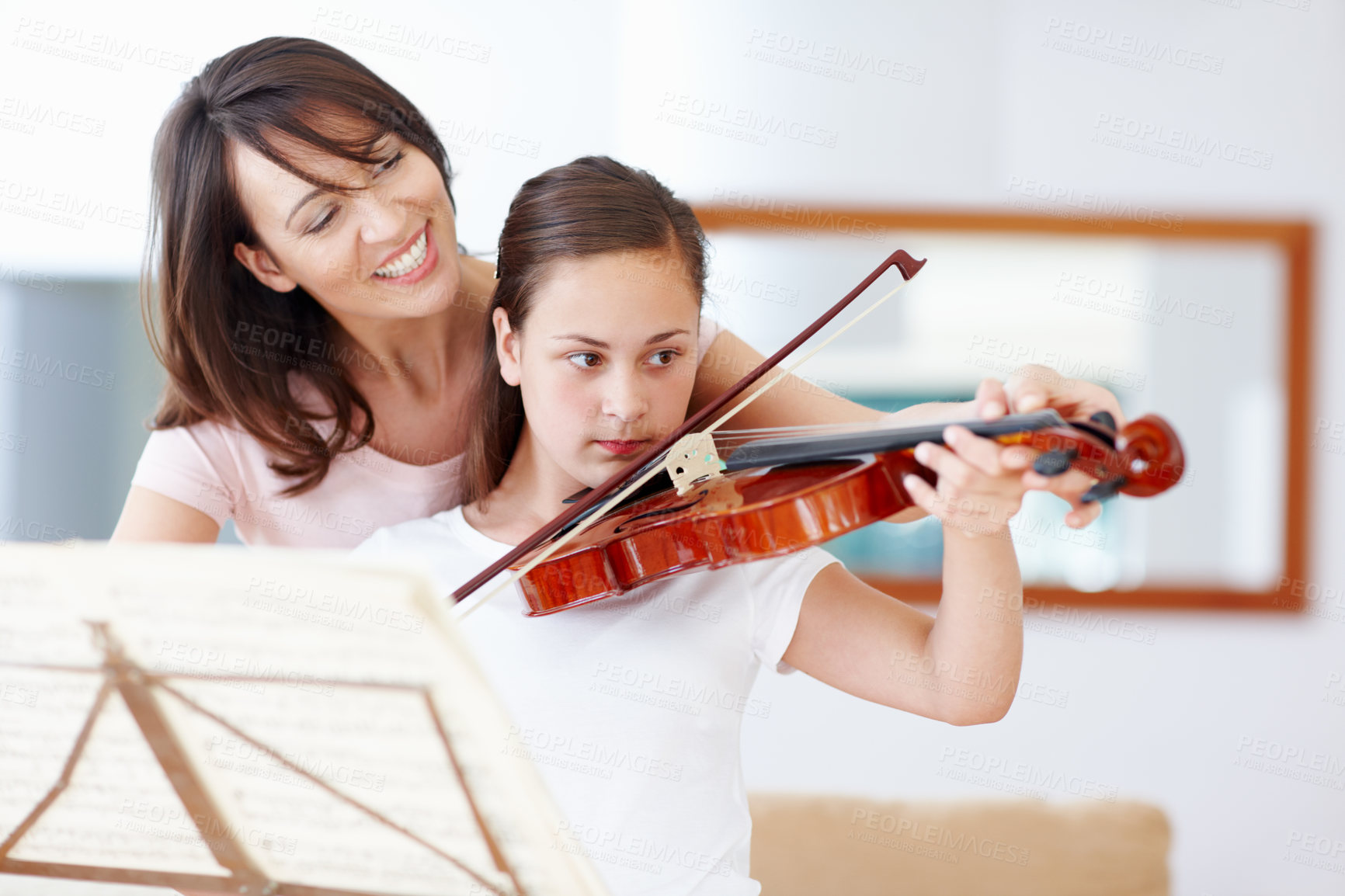 Buy stock photo A mother helping her daughter as she practices the violin - Copyspace