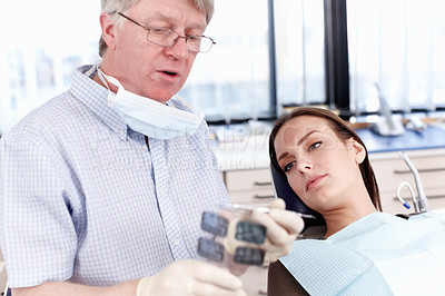 Buy stock photo Portrait of mature doctor showing dental x-ray to his female patient