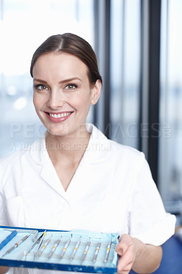Buy stock photo Portrait of lovely female dentist holding tools in office