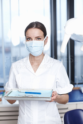 Buy stock photo Portrait of beautiful young female dentist holding tools in office