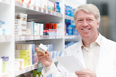 Smiling pharmacist with medicine and prescription
