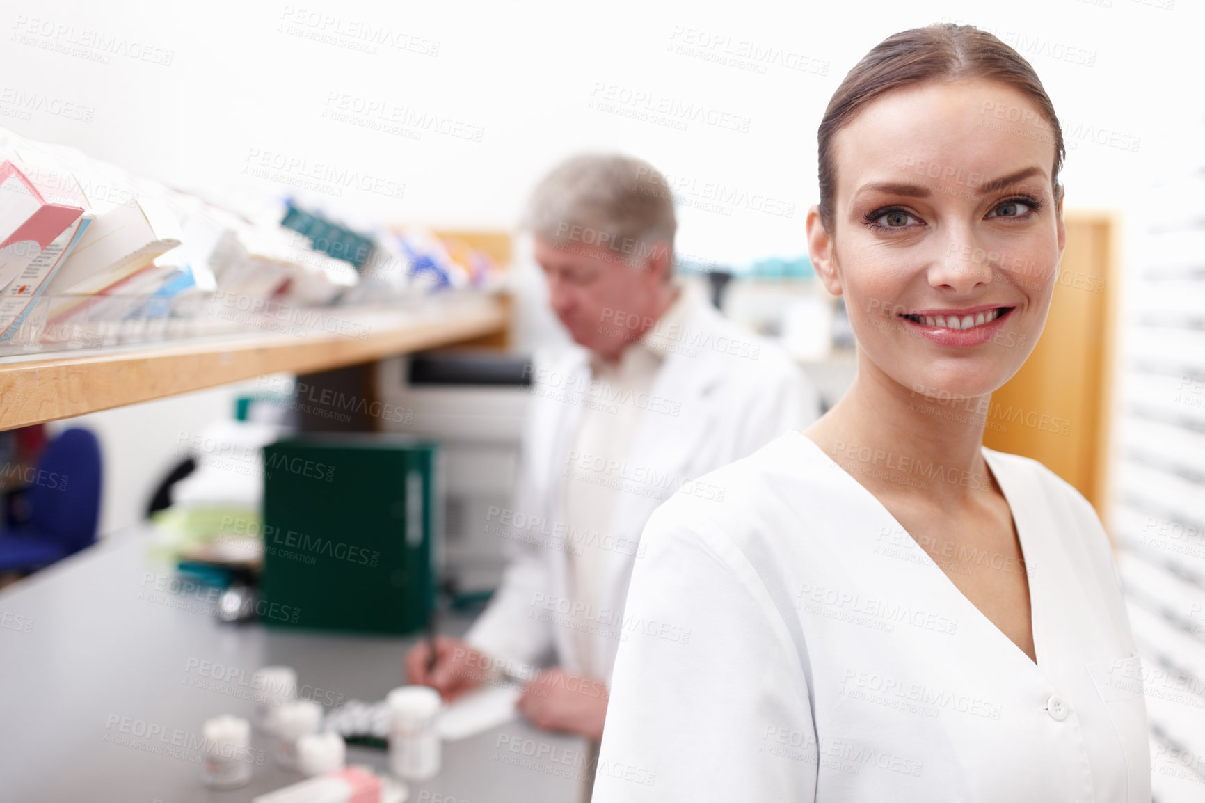 Buy stock photo Portrait of beautiful pharmacist smiling with male professional in background