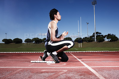 Buy stock photo A young athlete getting ready to start a race