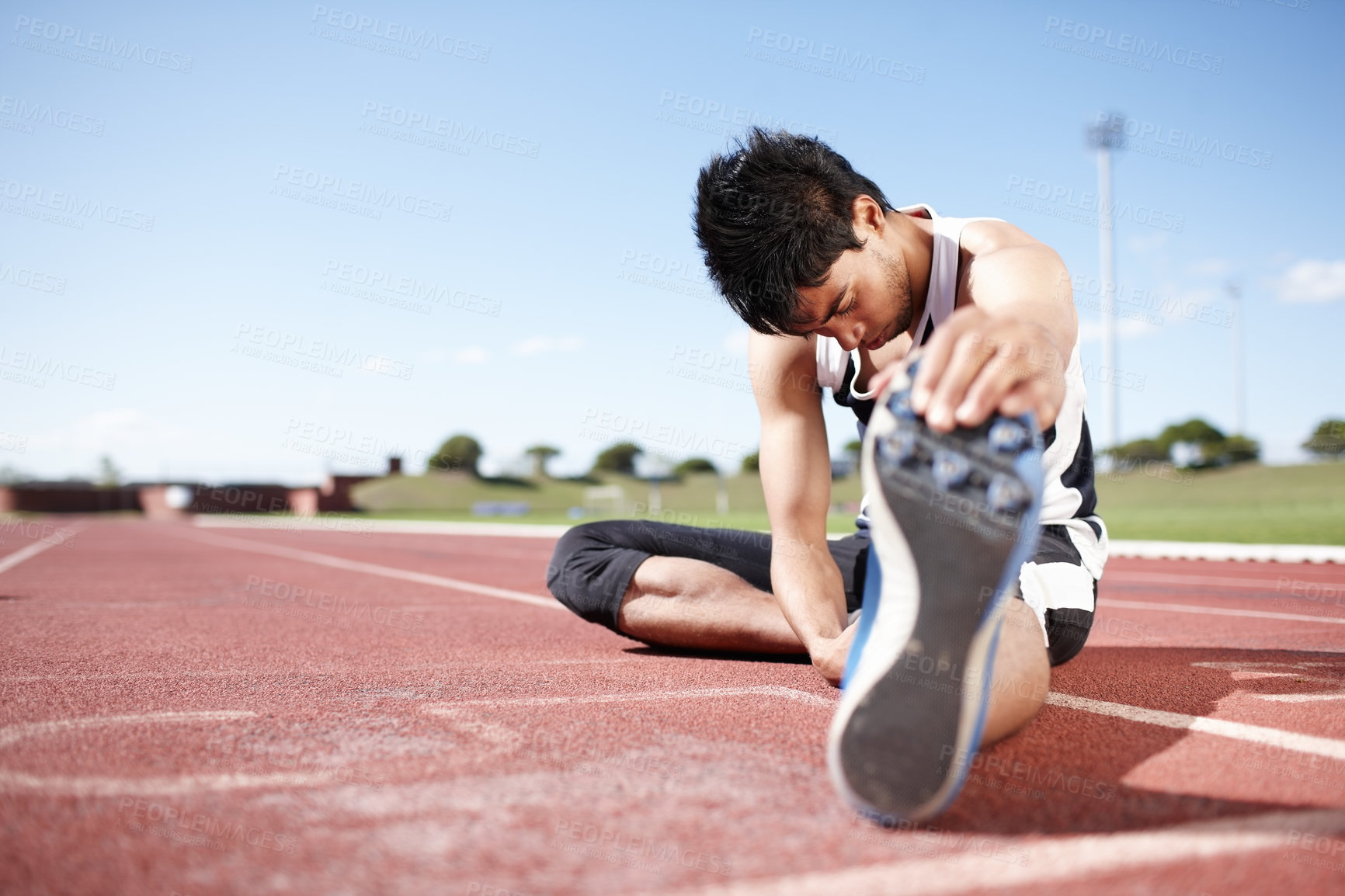 Buy stock photo Man, athlete and stretching legs on running track, warm up and preparation for exercise or workout. Male person, starting block and outdoor for fitness in sportswear, ready and marathon training