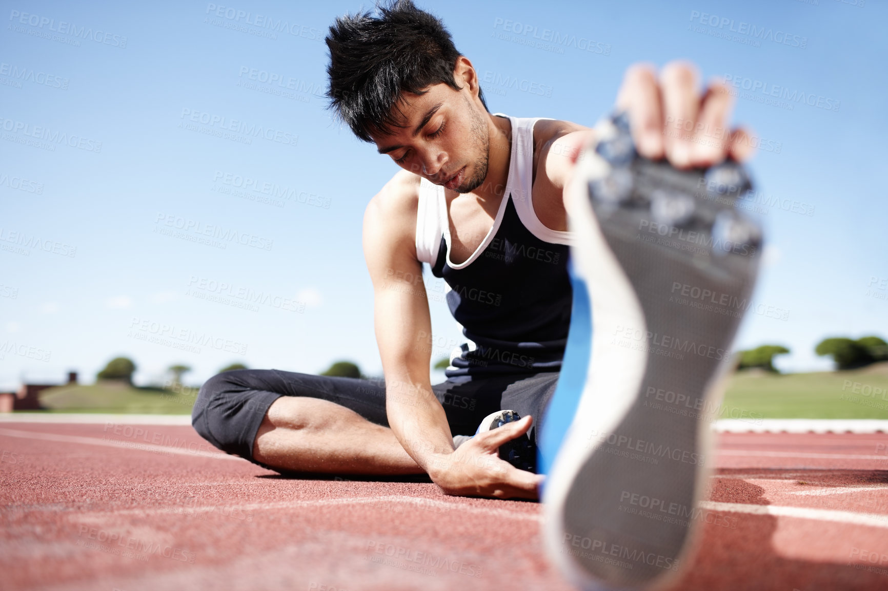 Buy stock photo Man, workout and stretching legs on running track, warm up and preparation for exercise on ground. Male person, start and outdoor for fitness in sportswear, athlete and ready for marathon training