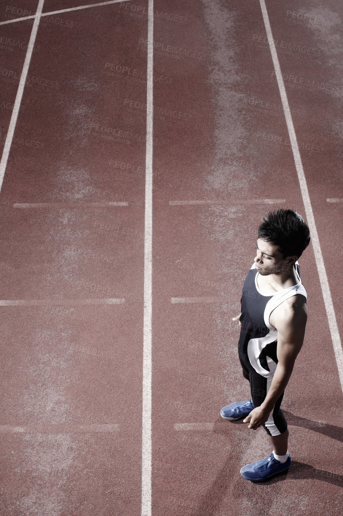 Buy stock photo Thinking, runner or top view of man on track for training, outdoor workout or sports exercise. Night, fitness and confident athlete waiting in stadium for running development or race performance