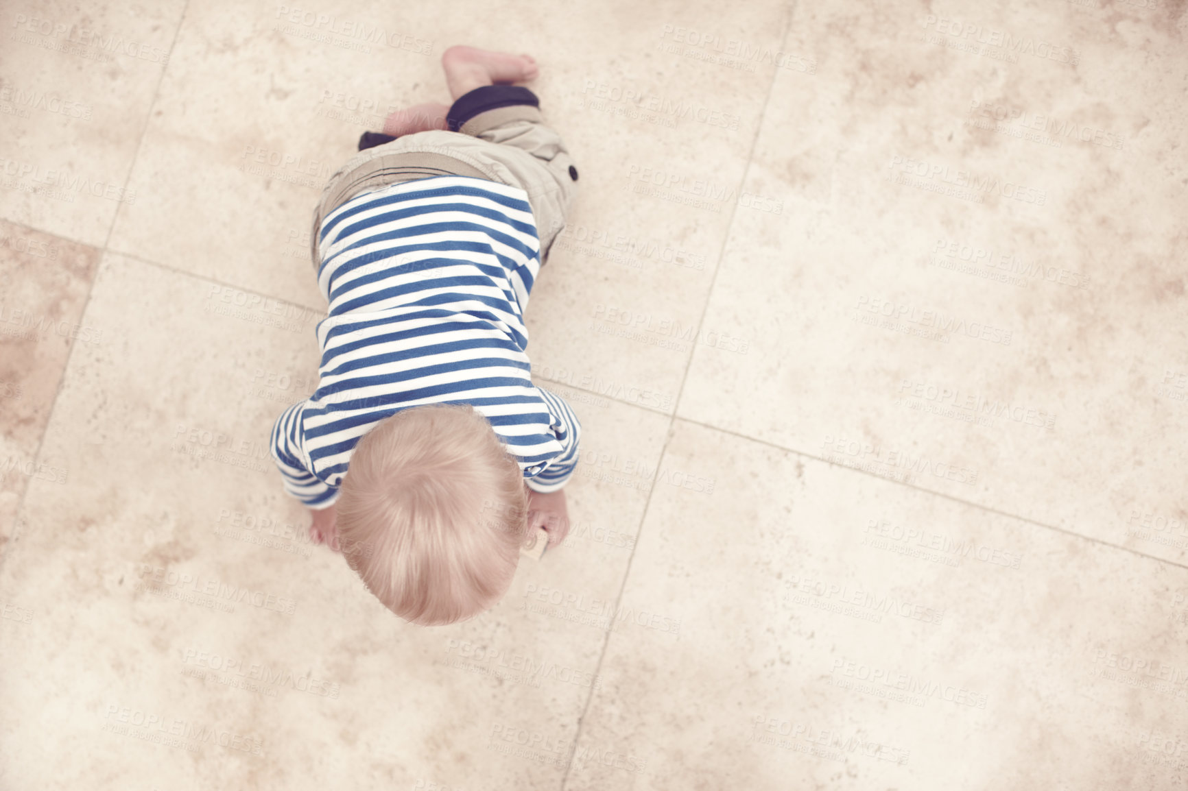 Buy stock photo High angle view of a baby boy crawling along the floor at home
