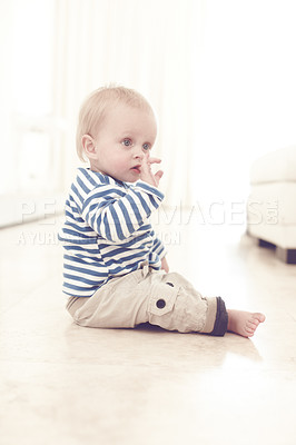 Buy stock photo A cute baby boy sitting on the floor at home