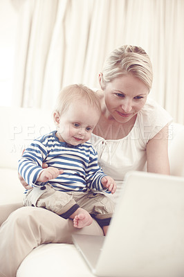 Buy stock photo An attractive young mother showing her curious baby a laptop