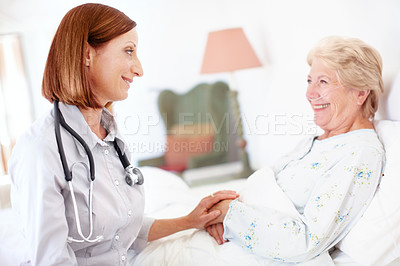 Buy stock photo A mature doctor checks in on an elderly female patient after an operation