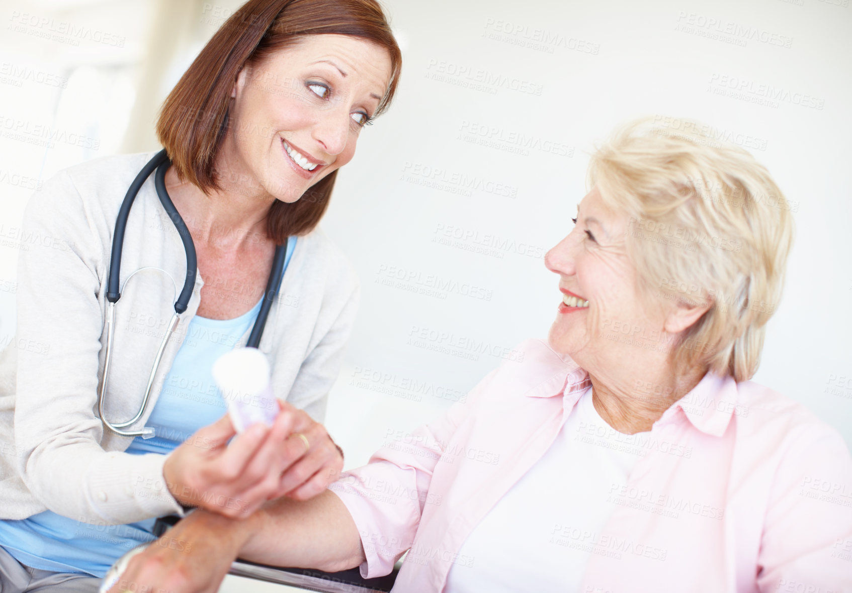 Buy stock photo Mature nurse and her senior female patient have a discussion about her medication