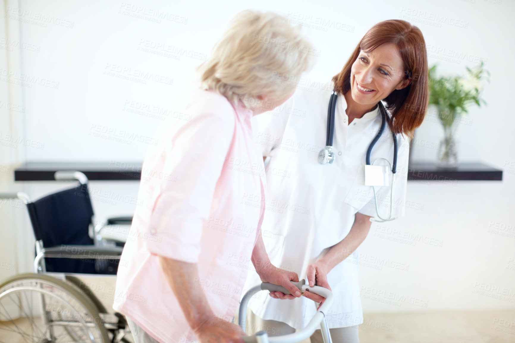 Buy stock photo Nurse and elderly patient look at one another while she assists her with a zimmer frame