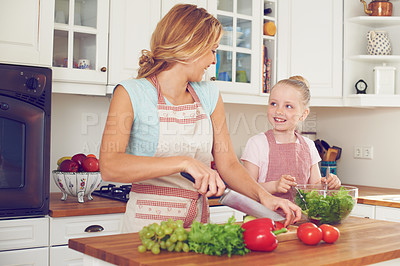 Buy stock photo Mother, kid and vegetables for salad in kitchen with cutting ingredients, meal prep and teaching healthy vegan recipe. Woman, girl and learning to cook with support, helping hand and bonding in home