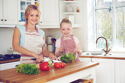 Buy stock photo Mother, child and portrait with salad in kitchen with cutting ingredients, meal prep and teaching healthy vegan recipe. Woman, girl and learning to cook with smile, helping hand and bonding in home