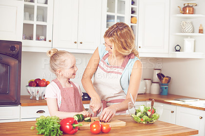 Buy stock photo Mother, kid and preparing a salad in kitchen with cutting ingredients, nutrition meal and teaching healthy vegan recipe. Woman, girl and learning to cook with support, helping hand or bonding in home