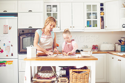 Buy stock photo Cute little girl baking in the kitchen with her mom