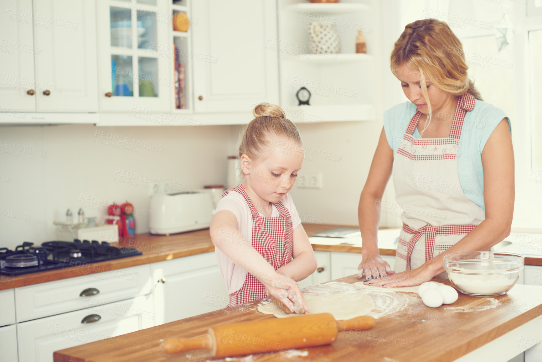 Buy stock photo Cute little girl baking in the kitchen with her mom