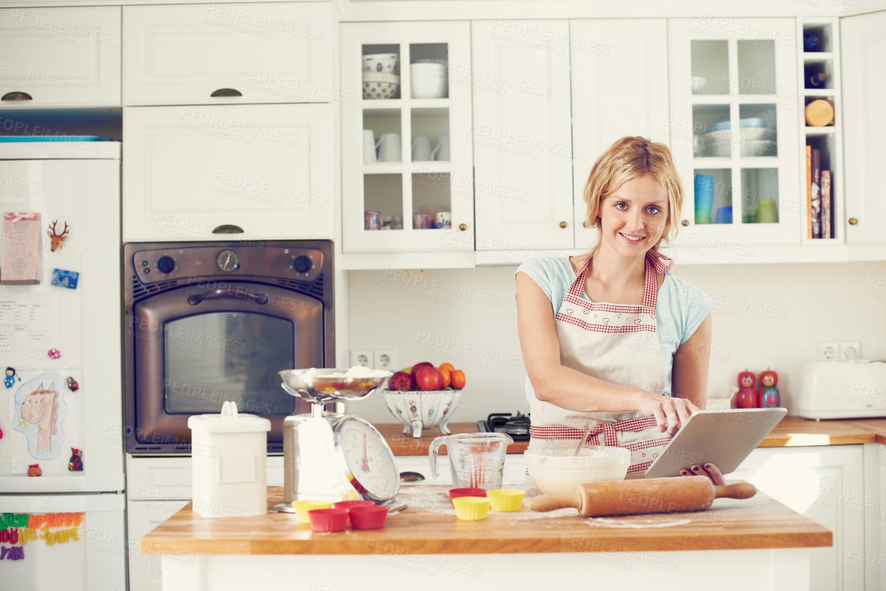 Buy stock photo Woman, tablet and portrait in kitchen for baking, cookies and online with video, bowl and streaming. Female person, tech and recipe in home for cooking, cupcakes and food with flour, wheat and tips