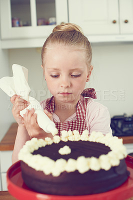 Buy stock photo Child, baking and cake decoration in kitchen with cream for dessert recipe, learning or development. Girl, kid baker or piping a buttercream topping for culinary education, preparation or sweet treat