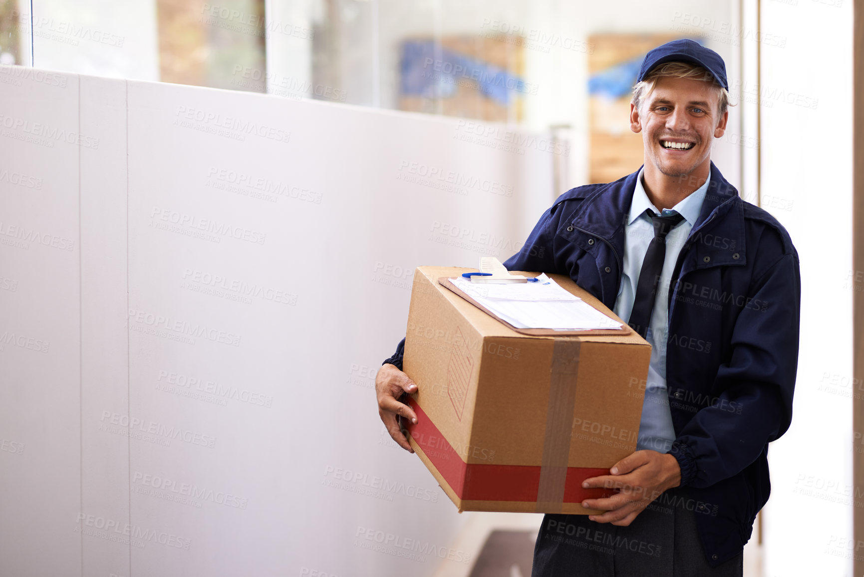 Buy stock photo Portrait of a confident young courier making a home delivery