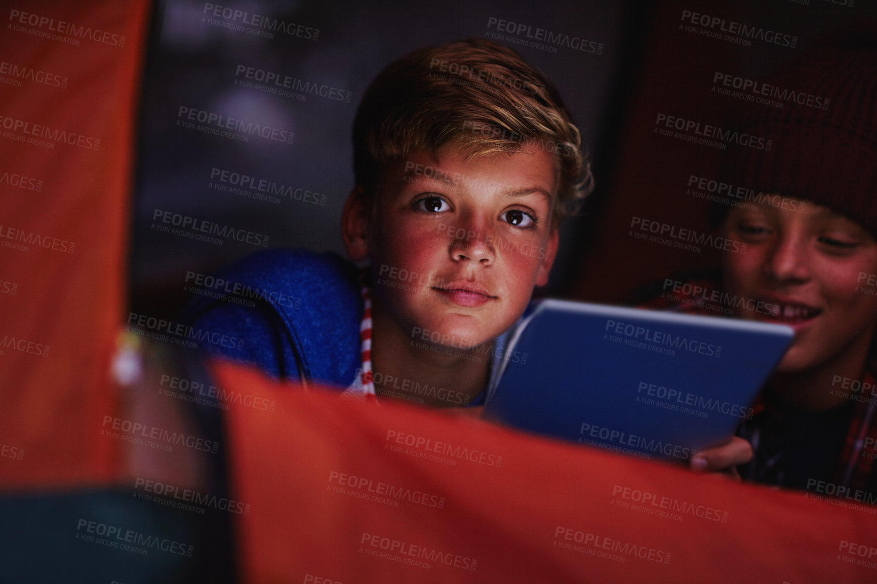 Buy stock photo Cropped shot of two young boys sharing a digital tablet while camping