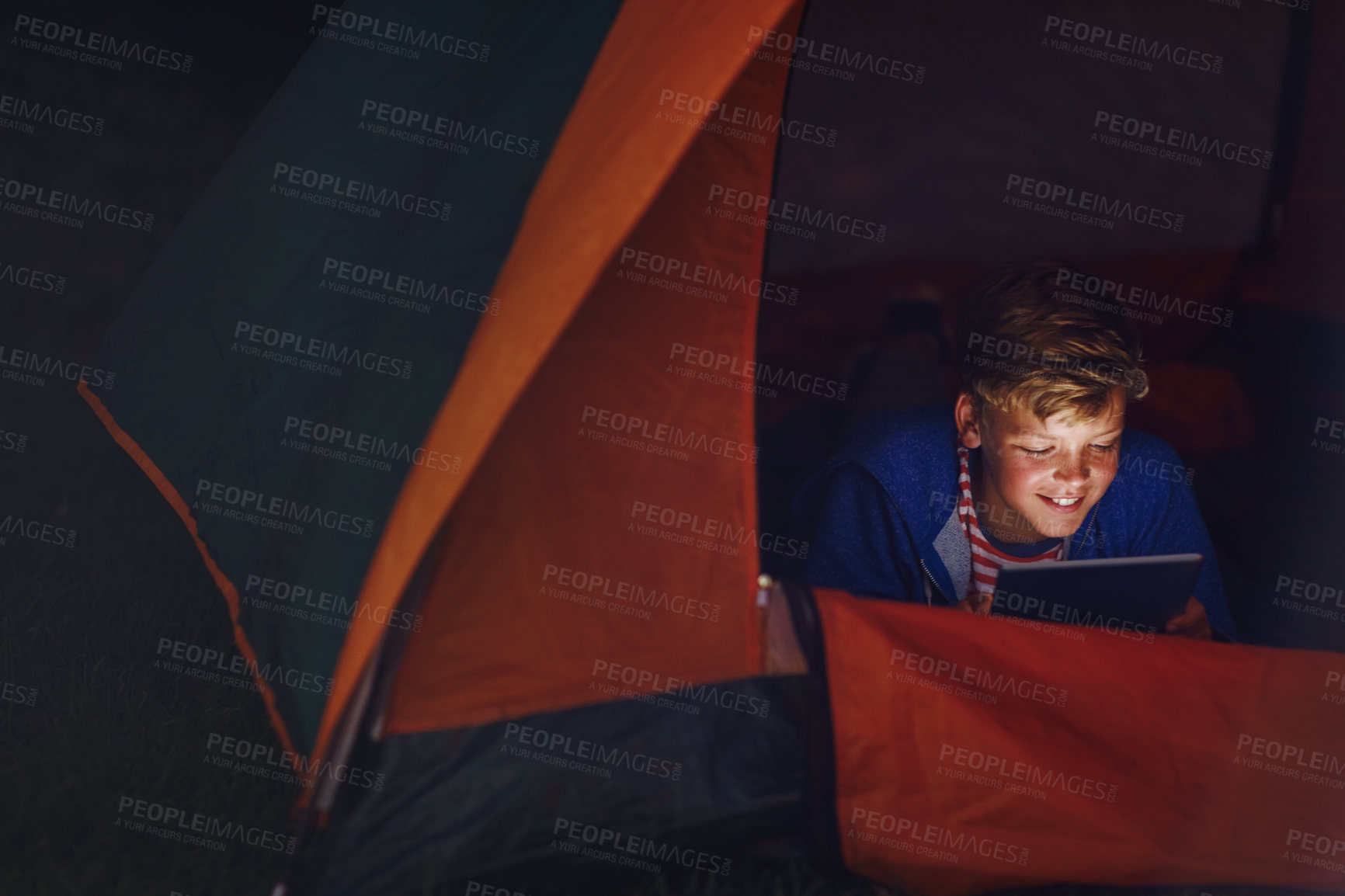 Buy stock photo Cropped shot of a young boy using a digital tablet while camping