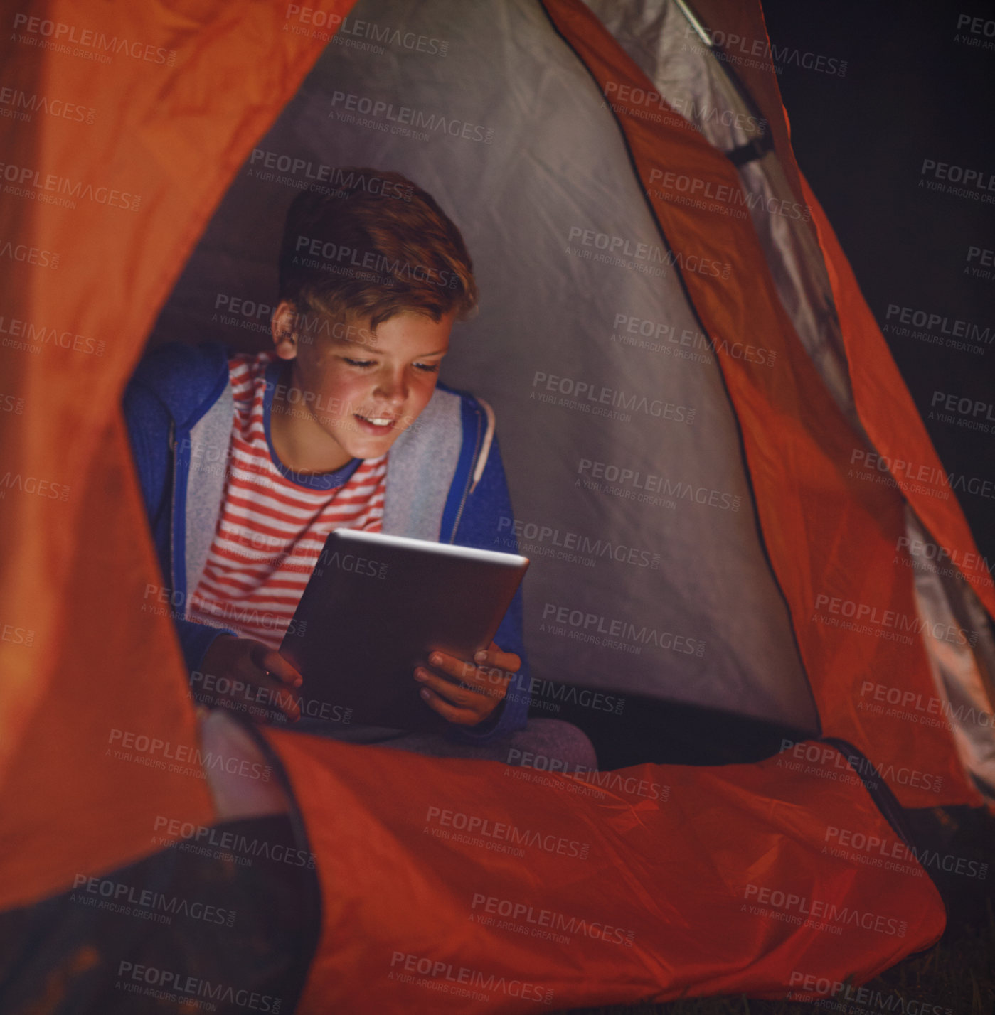 Buy stock photo Cropped shot of a young boy using a digital tablet while camping