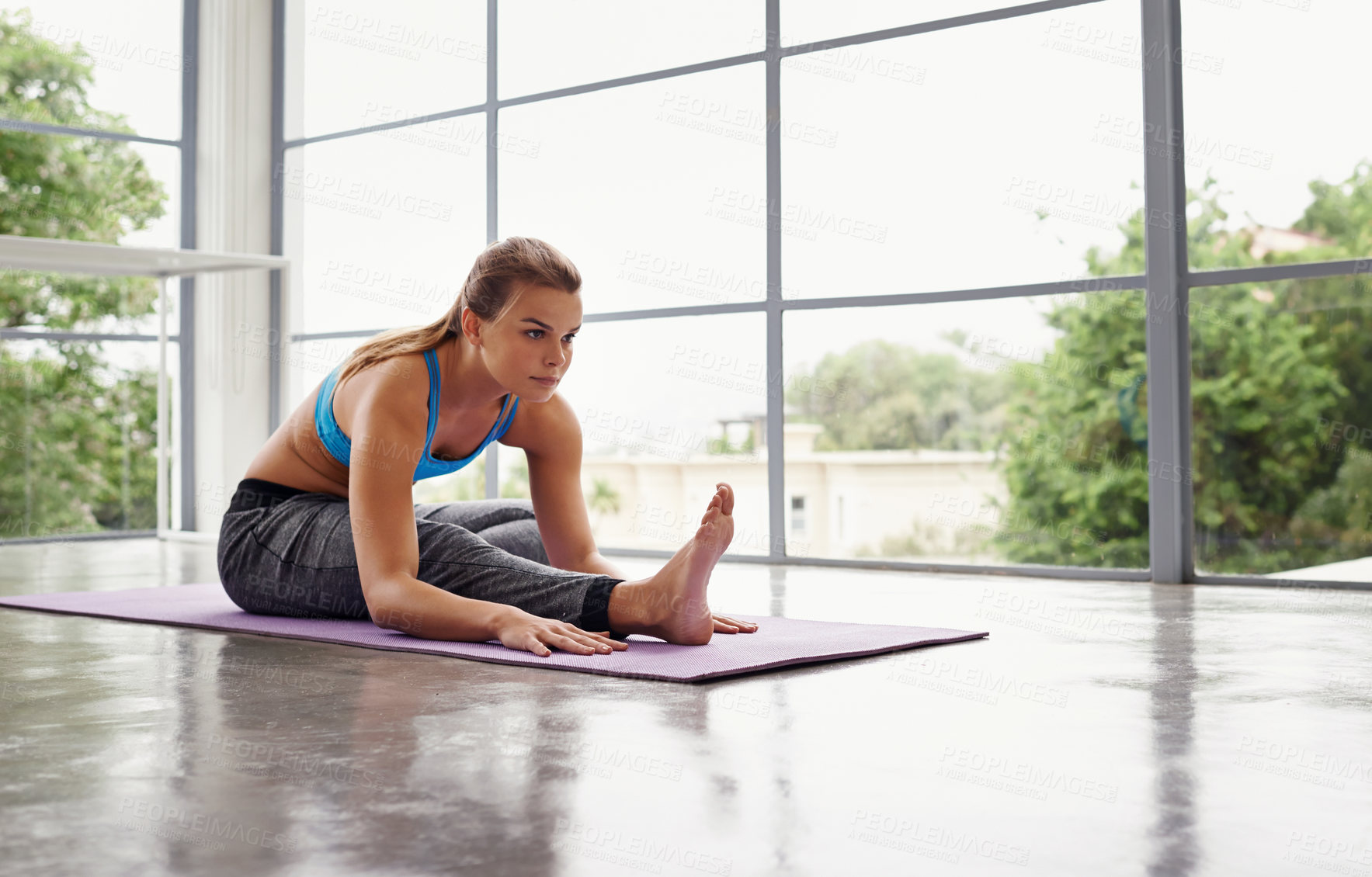 Buy stock photo Full length shot of a sporty woman practicing yoga at home