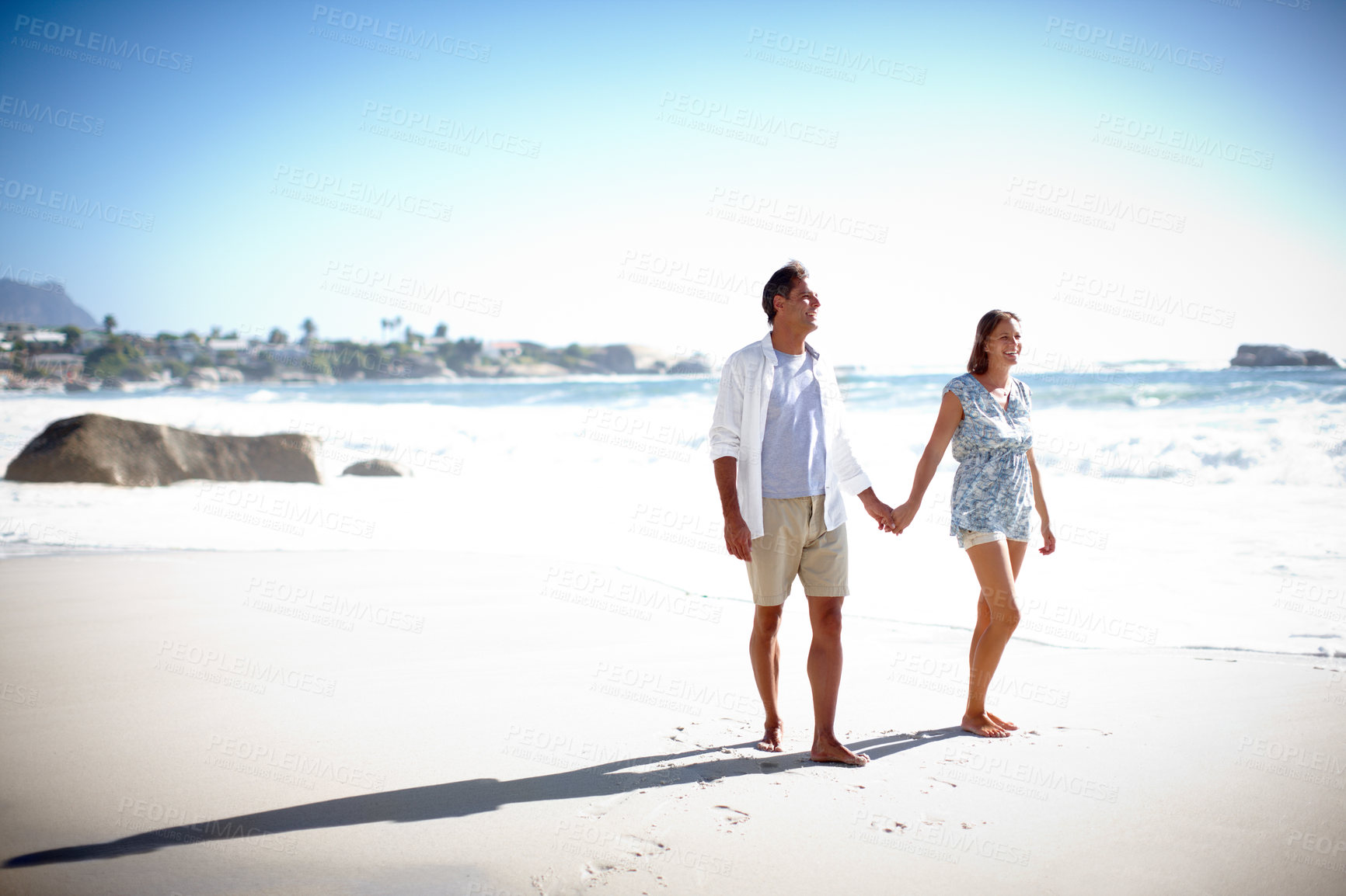 Buy stock photo A happy mature couple taking a relaxing stroll on the beach together