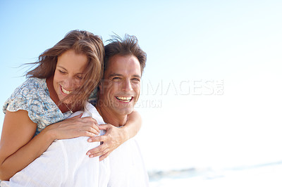 Buy stock photo Portrait of a mature man giving his happy wife a piggyback at the beach