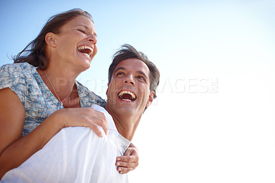 Buy stock photo A happy mature man giving his loving wife a piggyback while they both laugh