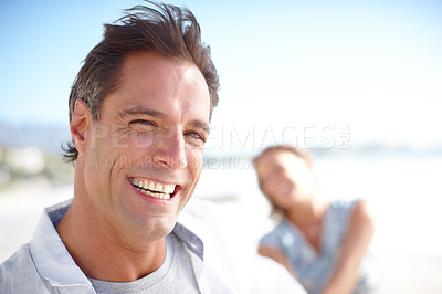 Buy stock photo Portrait of a happy mature man leading his wife by the hand while walking on the beach together