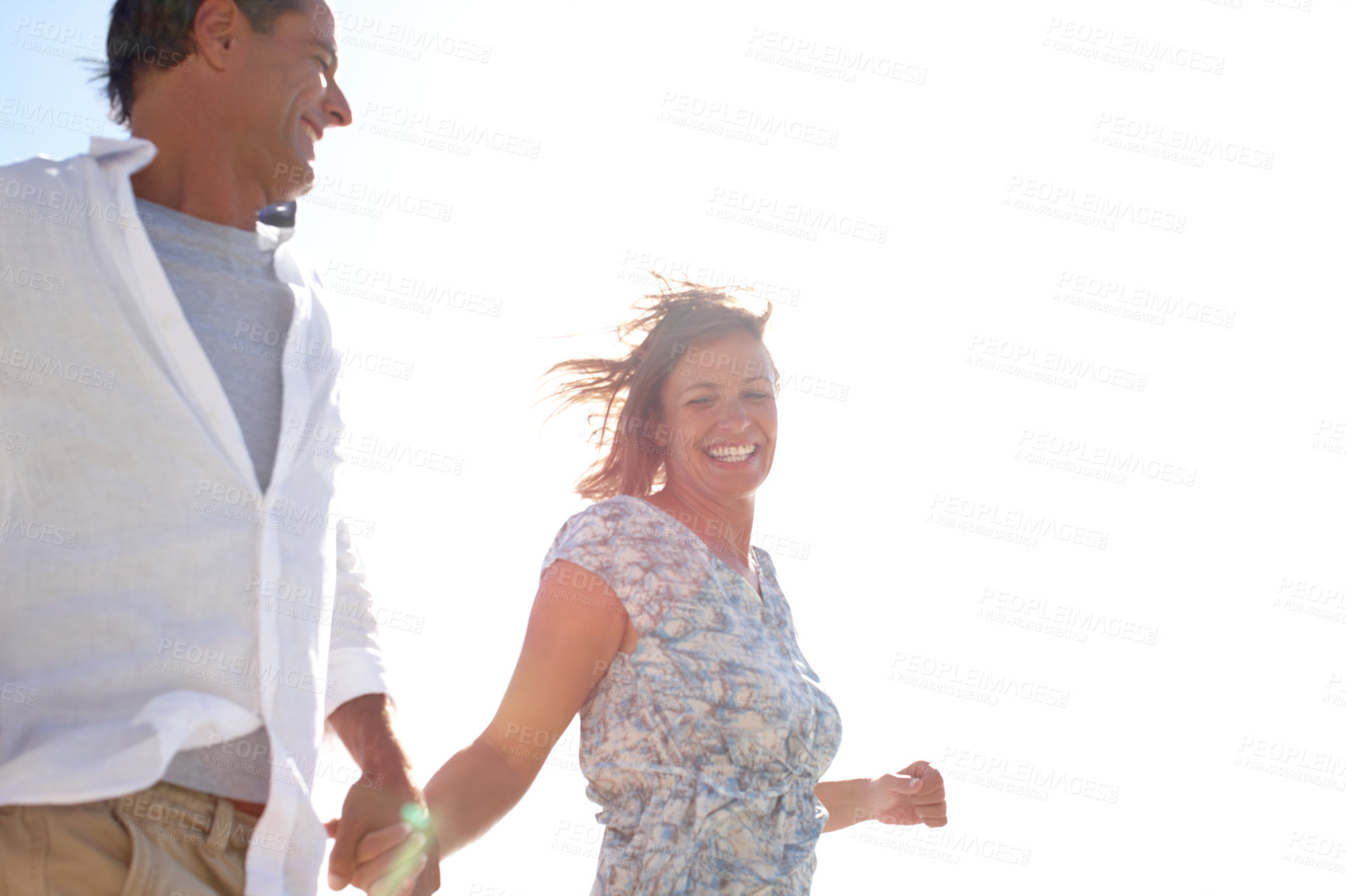 Buy stock photo Couple, holding hands and outdoor with freedom for love, travel and holiday adventure at space. Happy man, woman and running on beach with support, anniversary vacation and fun in windy Australia