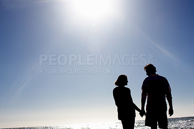 Buy stock photo Silhouette of a loving couple holding hands on the beach