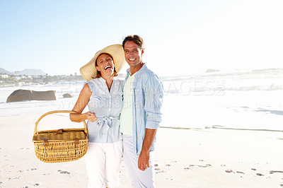 Buy stock photo Portrait of a happy mature couple going for a picnic on the beach together
