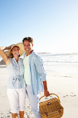Buy stock photo Portrait of a happy couple going for a picnic on the beach together