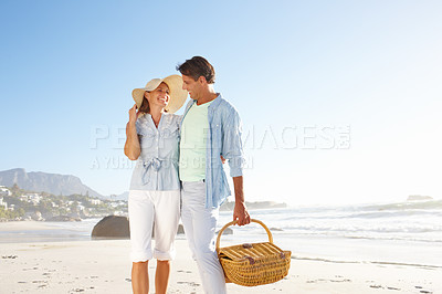 Buy stock photo A smiling couple going for a walk on the beach together - Copyspace