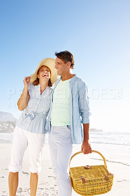 Buy stock photo A smiling couple going for a walk on the beach together