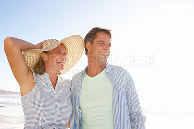 Buy stock photo A mature couple enjoying a walk on the beach together