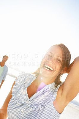 Buy stock photo Portrait of a pretty mature woman enjoying a day on the beach with her husband