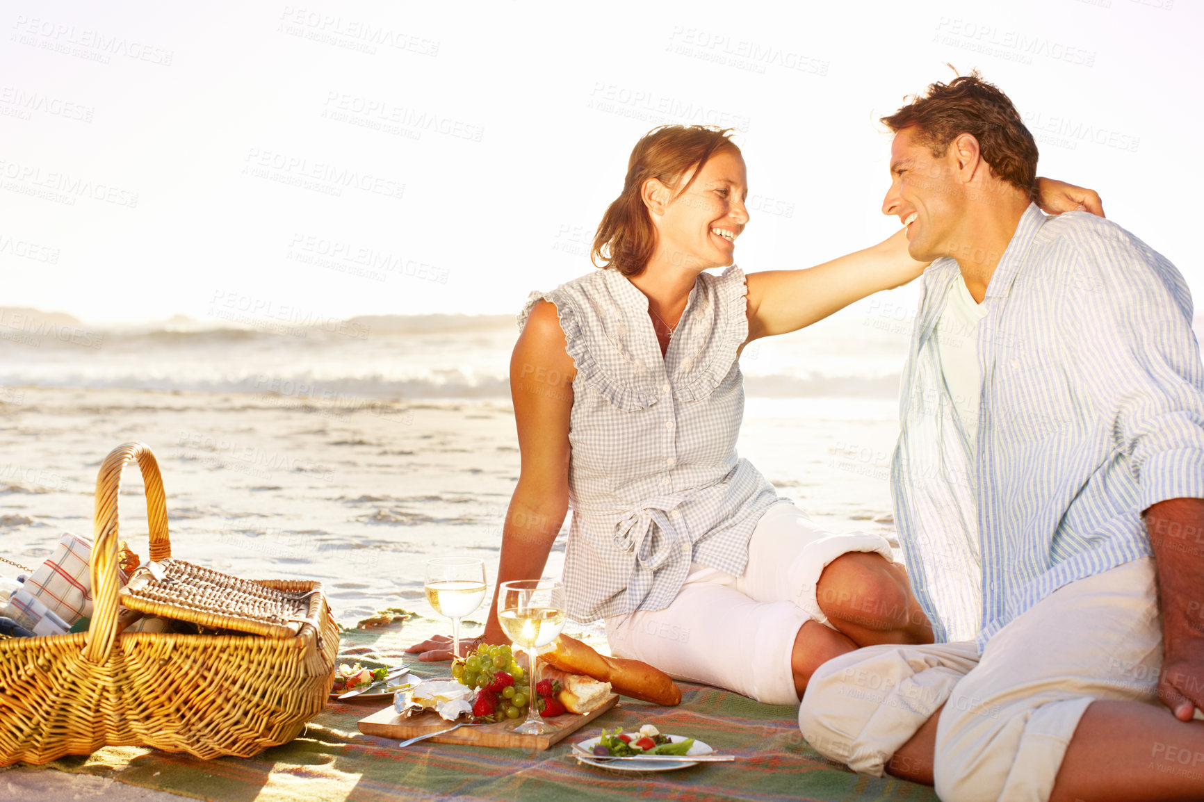 Buy stock photo Beach, couple and happiness on picnic with wine glass for support, romance and love in Bali. Seaside, people and smile in relationship on holiday, anniversary and honeymoon for valentines day