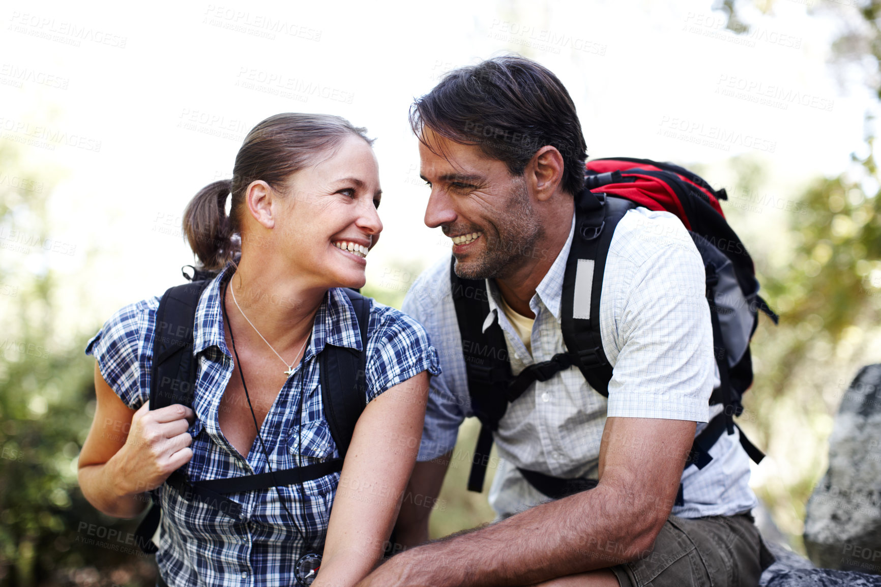 Buy stock photo Break, laughing or couple in nature for travel, outdoor adventure or hiking journey in woods. Love, joke or happy people in forest to relax together for holiday vacation or trekking to explore park