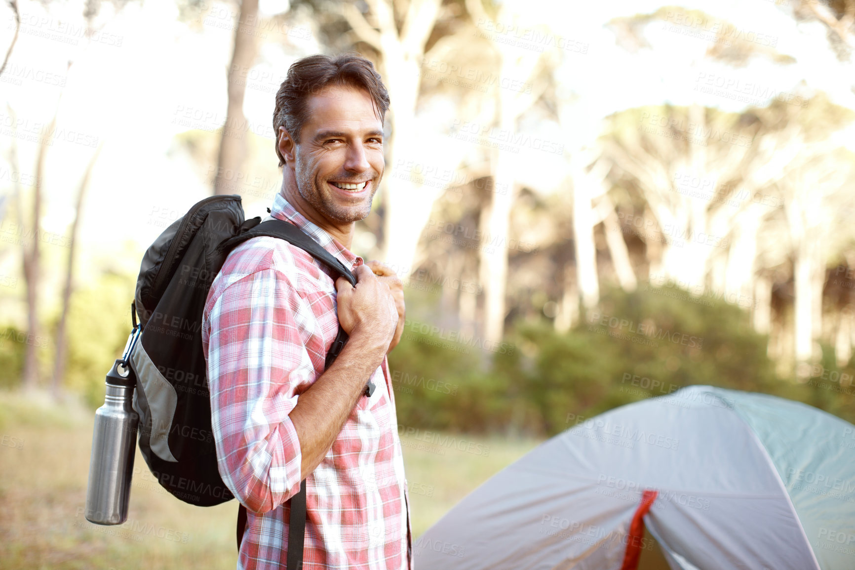 Buy stock photo Man, portrait and outdoor by tent for camping, backpack and smile with pride, adventure and journey in summer. Person, happy and bag with direction, travel and vacation with sunshine in Costa Rica