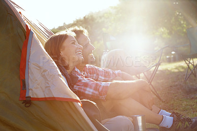Buy stock photo A young couple admiring nature while sitting by their tent