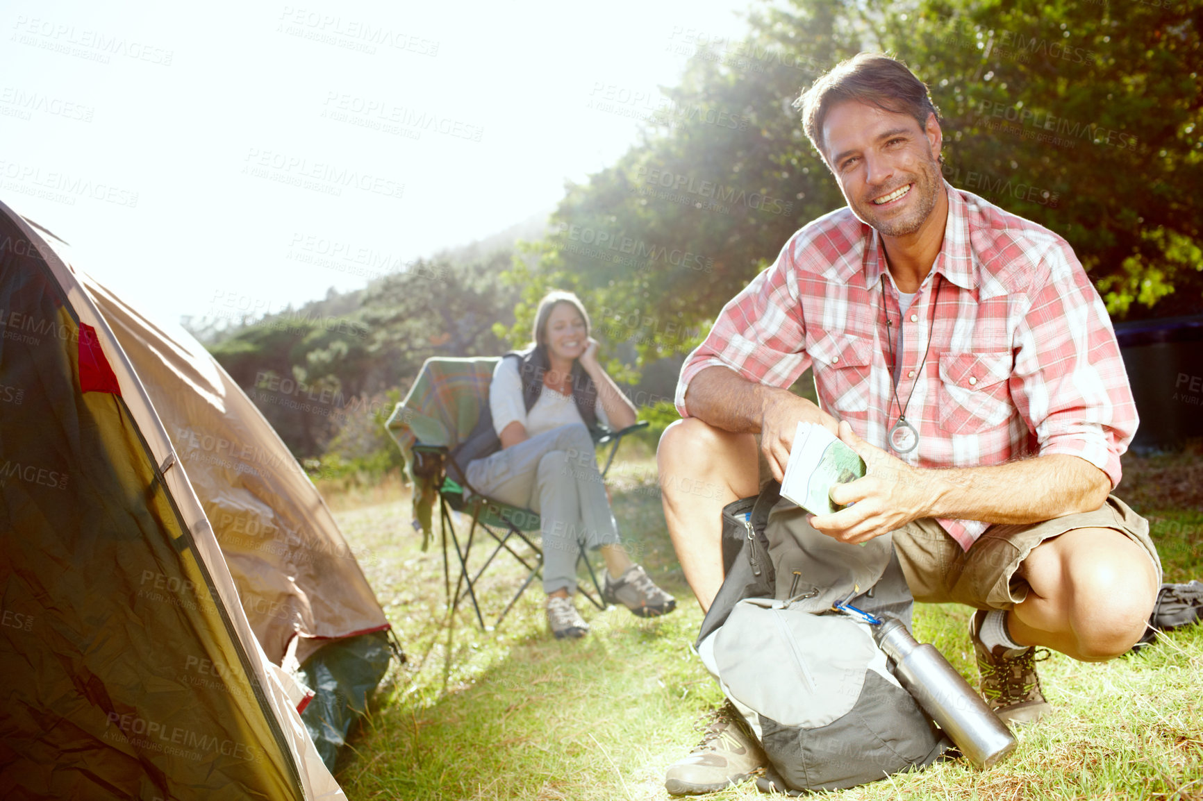 Buy stock photo Man, camping and portrait with map by tent on adventure with woman, partner and smile on grass in nature. Person, chart and navigation with trekking, happy and direction with vacation in Argentina