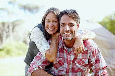 Buy stock photo A young couple smiling at the camera in front of a camping tent