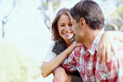 Buy stock photo A young couple looking at each other while sitting outside