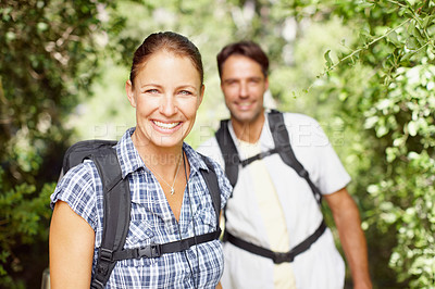 Buy stock photo Portrait of a young couple wearing backpacks and smiling at the camera