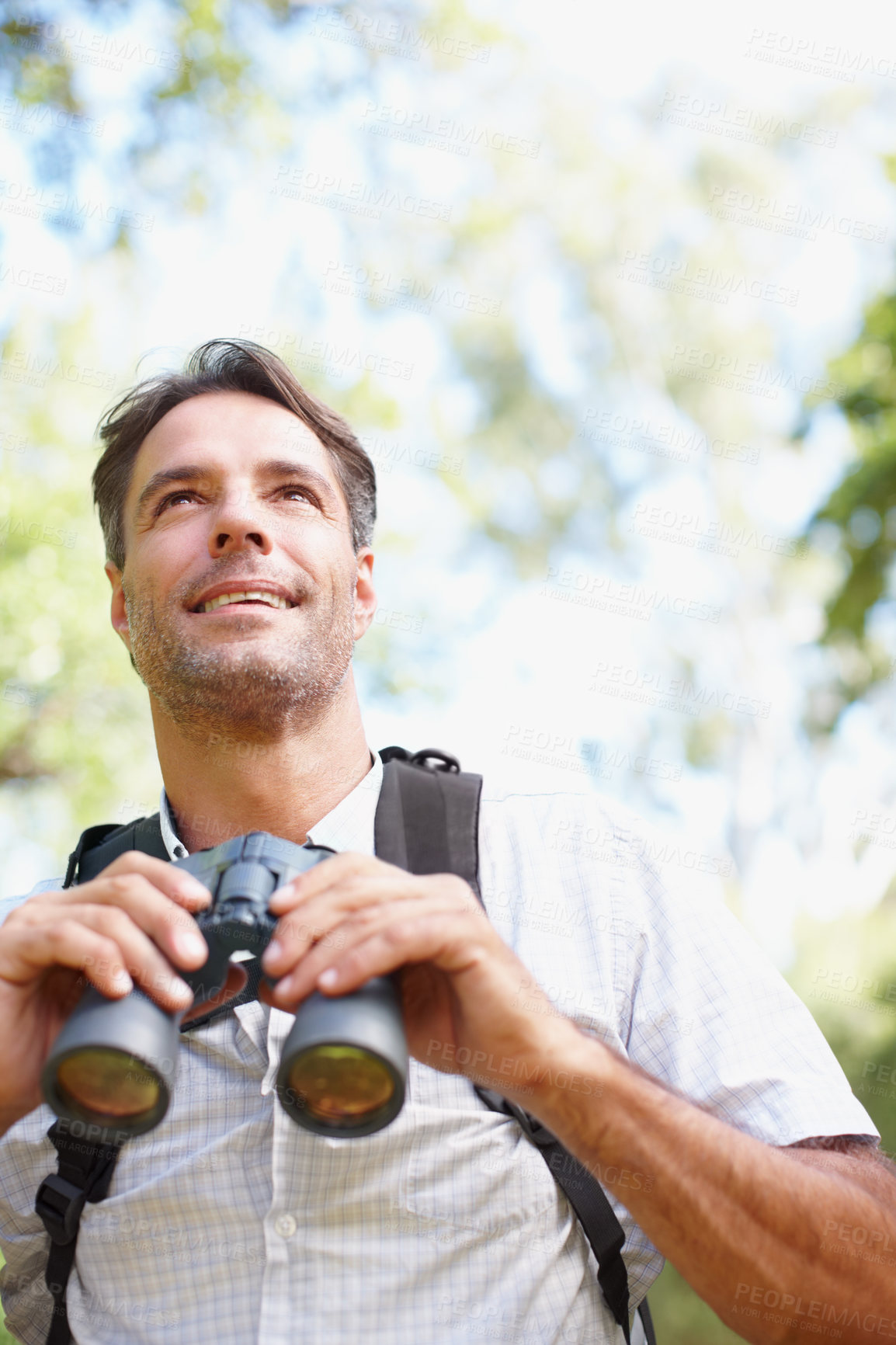 Buy stock photo Man, binoculars and outdoor journey in forest, tourist adventure and gear for nature discovery. Male person, countryside and glasses for bird watching or sightseeing, lens and explore wilderness